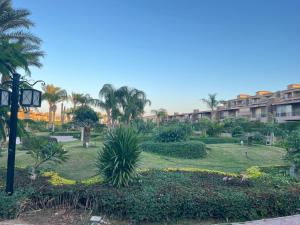 a park with palm trees and a building at شالية ارضى مميز فى السخنة in Ain Sokhna