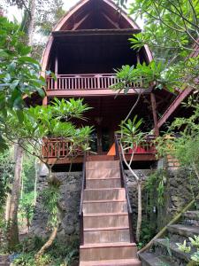 una escalera que conduce a una casa en el bosque en Bulian Homestay, en Kubutambahan
