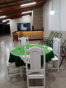 a dining room with a green table and chairs at Chácara de Lazer 2 Lagoas in Nova Esperança