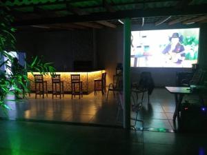 a room with a table and chairs and a projection screen at Chácara de Lazer 2 Lagoas in Nova Esperança