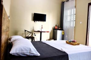 sypialnia z łóżkiem z telewizorem na ścianie w obiekcie Accra Luxury Apartments At The Sanga Estates w Akrze