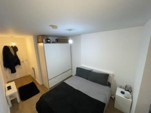 a bedroom with a bed and a white wall at Spacious and modern 2-bedroom flat near Canary Wharf in London in London