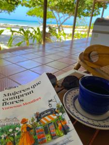 un livre assis sur une table avec une tasse de café dans l'établissement Carey Beach Baru, à Barú