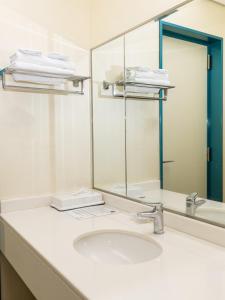 a bathroom with a sink and a mirror at Higashi Kumamoto Business Center in Ozu