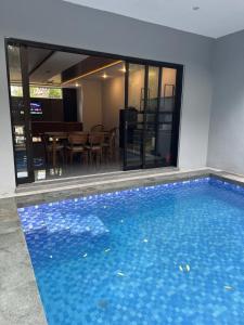 a swimming pool in a house with a dining room at Bwalk Hotel & Villa Malang in Sengkaling