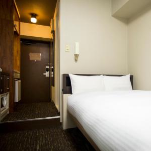 Postel nebo postele na pokoji v ubytování FLEXSTAY INN Kawasaki Kaizuka