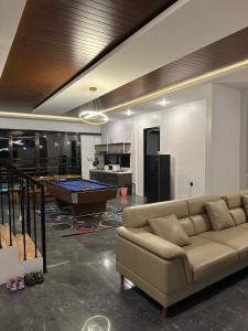 a living room with a couch and a pool table at Bwalk Hotel & Villa Malang in Sengkaling