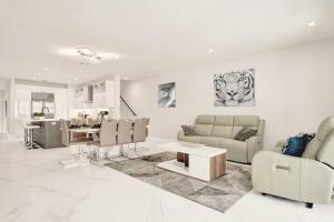 a white living room with a couch and a table at New 4BR w Pool Walk to Las Olas 5mins to Beach in Fort Lauderdale