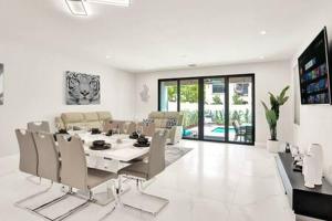 a dining room and living room with a table and chairs at New 4BR w Pool Walk to Las Olas 5mins to Beach in Fort Lauderdale