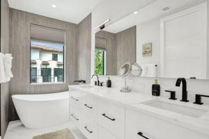 劳德代尔堡New 4BR w Pool Walk to Las Olas 5mins to Beach的配有两个水槽和一面大镜子的浴室