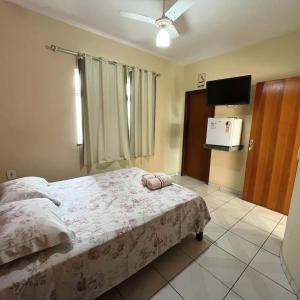 a bedroom with a bed and a flat screen tv at Hotel Mirante in Inhaúma