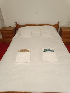 a bed with white sheets and two towels on it at Charlami's Mansion in Polýdroson