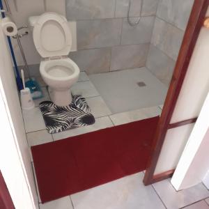ein Badezimmer mit einem WC und einem Zebra-Teppich auf dem Boden in der Unterkunft Nuutea lodge 2 in Avatoru