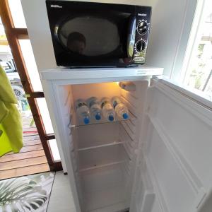 a microwave sitting on top of a refrigerator at Nuutea lodge 2 in Avatoru +15 photos