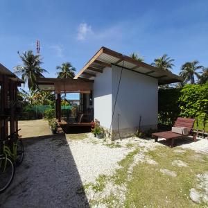 ein kleines Haus mit einer Bank und einem Picknicktisch in der Unterkunft Nuutea lodge 2 in Avatoru