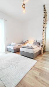 twee bedden in een kamer met een tapijt bij Traumschlösschen EG in Nossen
