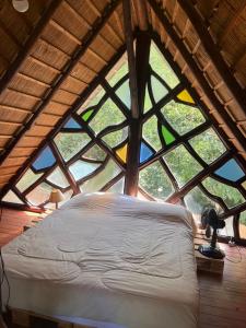 a bed in a room with a large window at Cabaña bosque y mar in Salinas 