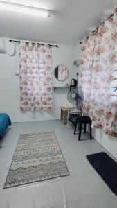 uma sala de estar com duas cortinas e um tapete em Pak Long Man Roomstay em Pendang