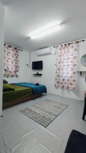um quarto com uma cama, uma televisão e cortinas em Pak Long Man Roomstay em Pendang