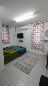 a small room with a bed and two windows at Pak Long Man Roomstay in Pendang