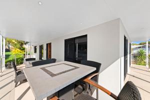 a dining table on the balcony of a house at Tomaree Road 16 in Shoal Bay