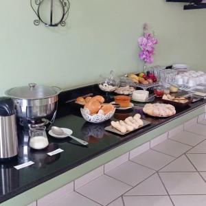 a buffet with many different types of food on a counter at Hotel Mirante in Inhaúma