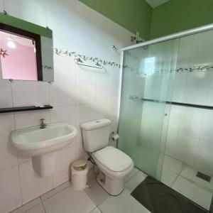 a bathroom with a toilet and a sink and a shower at Hotel Mirante in Inhaúma