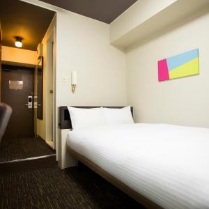 Postel nebo postele na pokoji v ubytování FLEXSTAY INN Kawasaki Kaizuka