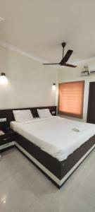 a bedroom with a large white bed with a ceiling at Stayz Inn Hotels - T nagar Chennai Near Pondy Bazzar in Chennai