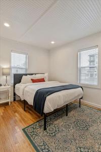 a bedroom with a bed with a rug and two windows at Located in the heart of Provo Right off i15 in Provo