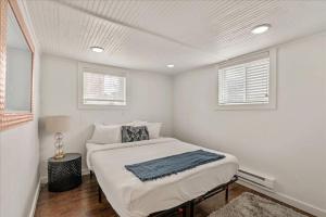 a white bedroom with a bed and two windows at Located in the heart of Provo Right off i15 in Provo