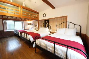 a bedroom with two beds with red sheets at YKHouse 尾道から車で10分 駐車場完備 in Mihara