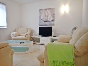 salon z 2 krzesłami i telewizorem w obiekcie Apartment in Starigrad-Paklenica 34801 w mieście Starigrad-Paklenica