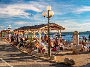a group of people sitting in chairs under a pavilion near the water at Holiday home in Jasenice 40484 in Jasenice