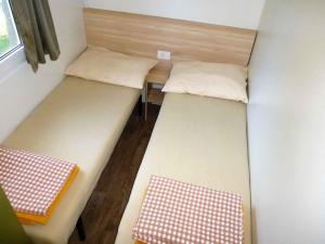 mały pokój z 2 łóżkami i stołem w obiekcie Mobilehomes in Seline - Paklenica Riviera 6831 w mieście Seline