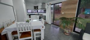 a kitchen with a white table and chairs in a room at Tatitos Homes El Pinar - Apartamento vacacional - in Ciudad de la Costa