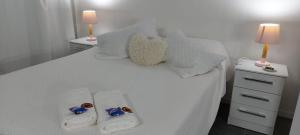 1 cama blanca con 2 toallas y almohadas en Tatitos Homes El Pinar - Apartamento vacacional -, en Ciudad de la Costa
