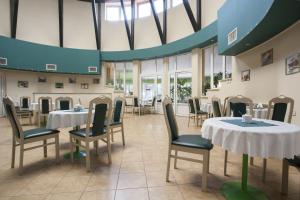 a dining room with tables and chairs and windows at Relaks Domki pod Górą Żar in Międzybrodzie Żywieckie