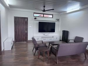 a living room with a couch and a flat screen tv at BKR Homestay 1BH in Itānagar