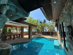 Beach Bungalow at Lanta Resort في كو لانتا: مسبح في منزل بجدار حجري