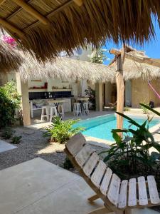 a resort with a swimming pool and a straw umbrella at Casa Terra in Paso Hondo