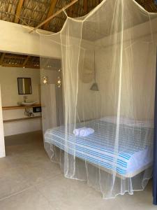 a bedroom with a bed covered in mosquito nets at Casa Terra in Paso Hondo