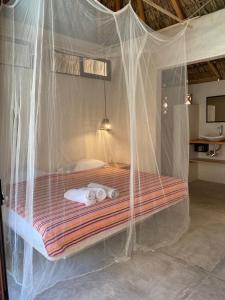 a bed covered in mosquito nets in a room at Casa Terra in Paso Hondo