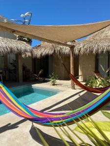 a hammock in front of a house with a pool at Casa Terra in Paso Hondo