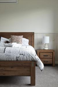 ein Schlafzimmer mit einem Bett und einem Tisch mit einer Lampe in der Unterkunft Blue Haven In Bright Victoria in Bright