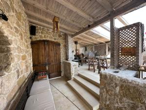 ein Raum mit einer Steinmauer und einem Tisch in der Unterkunft Villa Mediterranea in Krasići