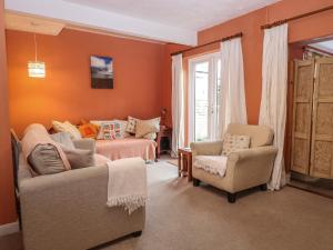a living room with a bed and a couch and chairs at Sea Pearl in Lowestoft