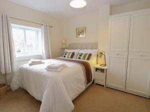 a white bedroom with a bed and a window at Sea Pearl in Lowestoft