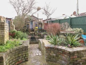 a garden with a brick wall and some plants at Sea Pearl in Lowestoft