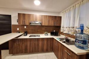 a kitchen with wooden cabinets and a bottle of water at Departamento Vistas de Patzcuaro con terraza vista hacia el lago in Pátzcuaro